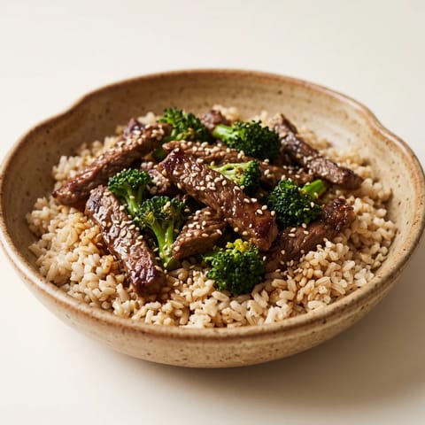Beef & Broccoli Grain Bowl with Tamari Dressing - Seared beef strips over brown rice and broccoli with a gingery tamari dressing