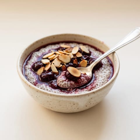 Cherry & Almond Chia Pudding - Vanilla chia pudding under a spoon of warm cherry compote and toasted almonds