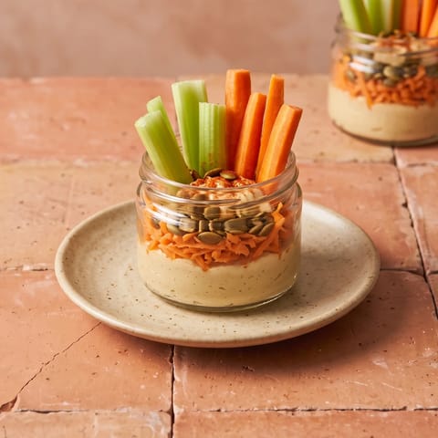 Hummus & Carrot Snack Jars - Layered jars of hummus, grated carrot and seeds with veg sticks standing in like flowers