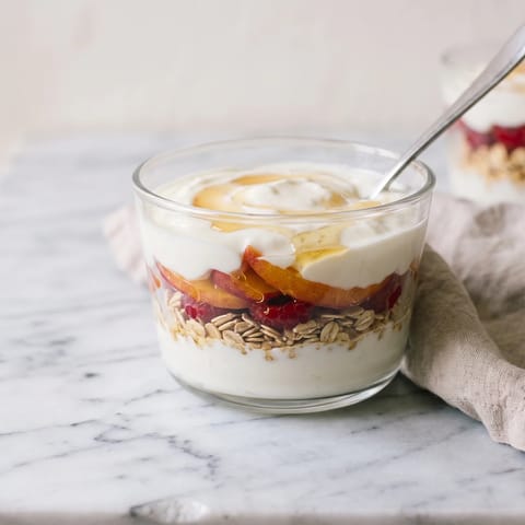 Peach Melba Yogurt Parfait - Layers of thick yogurt, warm honeyed peaches and raspberry smash with toasted oats