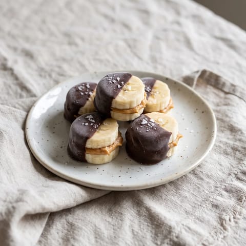 Peanut Butter Banana Frozen Bites - Banana coins sandwiched with peanut butter, kissed with dark chocolate and frozen