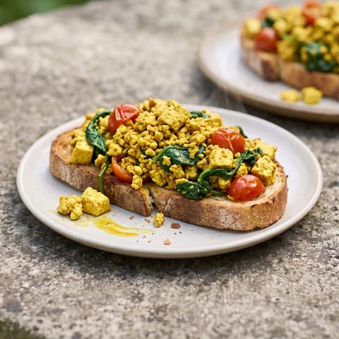 Tofu & Spinach Breakfast Scramble on Toast - Turmeric-golden tofu scramble with spinach and cherry tomatoes on toast