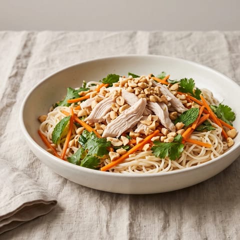Vietnamese-Style Chicken Noodle Salad - Rice noodles, poached chicken, pickled carrot and a pile of herbs with nuoc-cham-style dressing