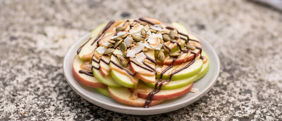 Apple Nachos with Peanut Butter Drizzle - Crisp apple slices fanned out under warm peanut butter, dark chocolate and toasted seeds