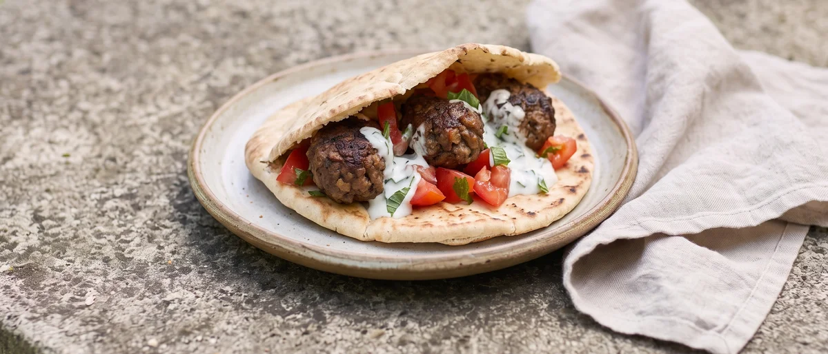 Beef Kofta Pitas with Tomato & Mint Yogurt - Spiced beef koftas cooked through and tucked into pitas with tomatoes and cool mint yogurt