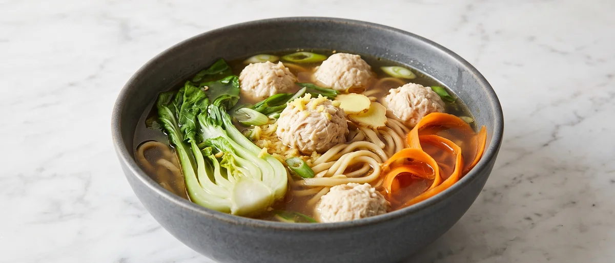 Chicken & Vegetable Dumpling-Style Noodle Soup - Ginger-poached chicken and wontons' spirit without the wrapping: plump chicken meatballs in a scallion broth with noodles and greens.