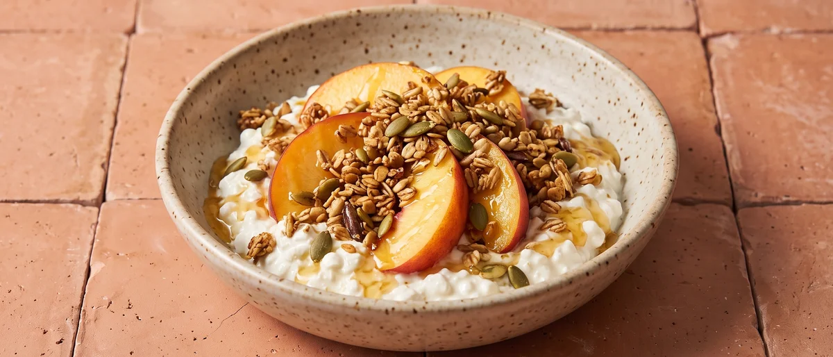 Cottage Cheese Power Bowl with Peaches & Granola - Cottage cheese under juicy peaches, granola and honey