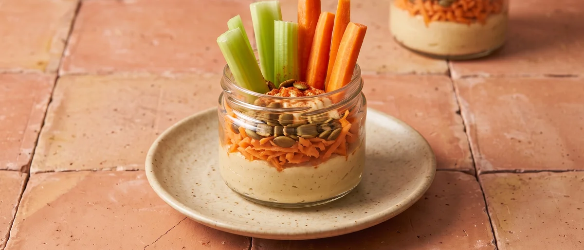 Hummus & Carrot Snack Jars - Layered jars of hummus, grated carrot and seeds with veg sticks standing in like flowers