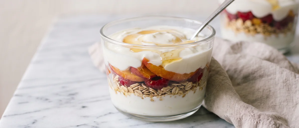 Peach Melba Yogurt Parfait - Layers of thick yogurt, warm honeyed peaches and raspberry smash with toasted oats