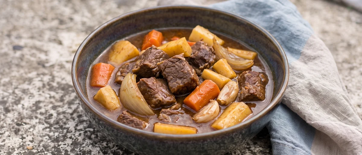 Slow-Cooker Beef & Root Vegetable Stew - Beef, carrots and parsnips in a thyme-scented gravy: twenty-five minutes of morning effort, then the slow cooker handles dinner while the baby naps.
