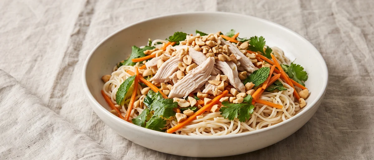 Vietnamese-Style Chicken Noodle Salad - Rice noodles, poached chicken, pickled carrot and a pile of herbs with nuoc-cham-style dressing